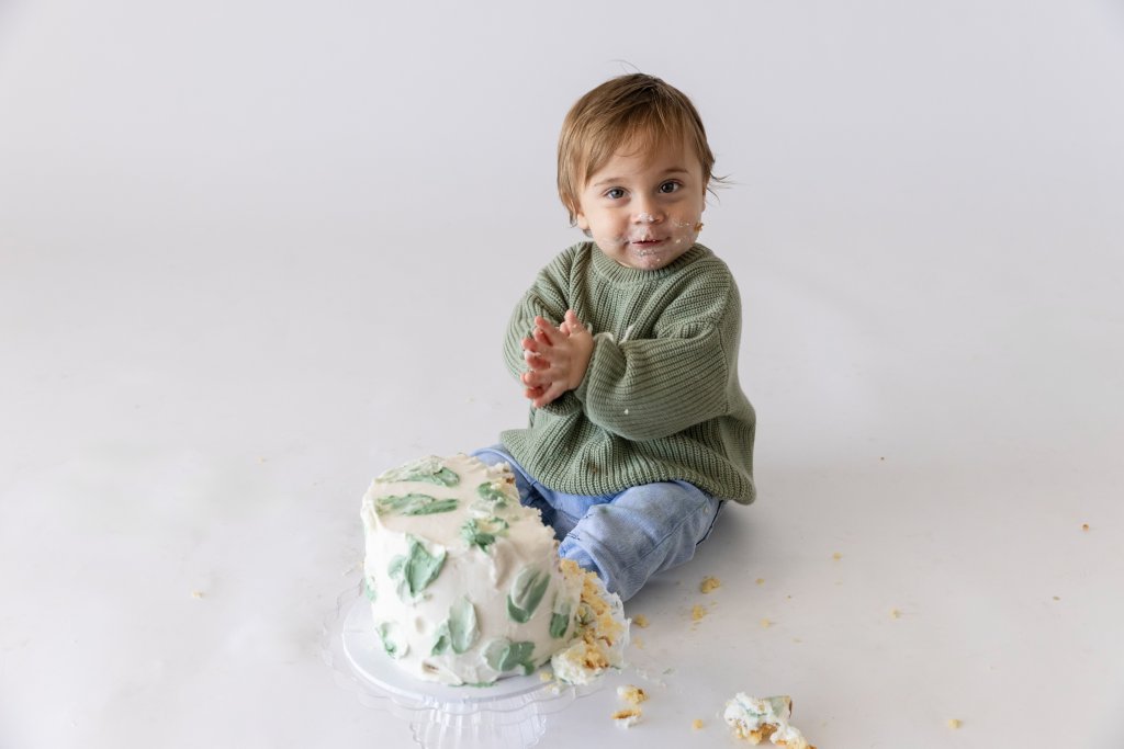One year old boy diving into birthday cake, first birthday photography Perth