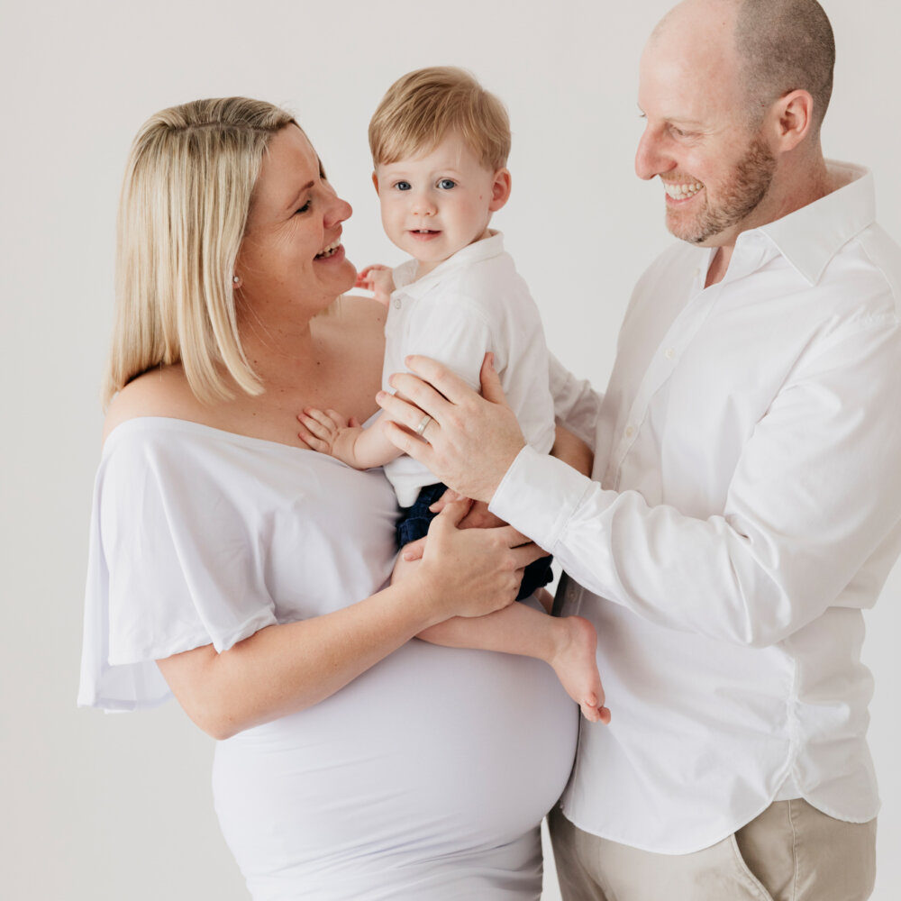 pregnant mum and partner holding toddler boy, studio maternity photography Perth