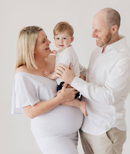 pregnant mum and partner holding toddler boy, studio maternity photography Perth