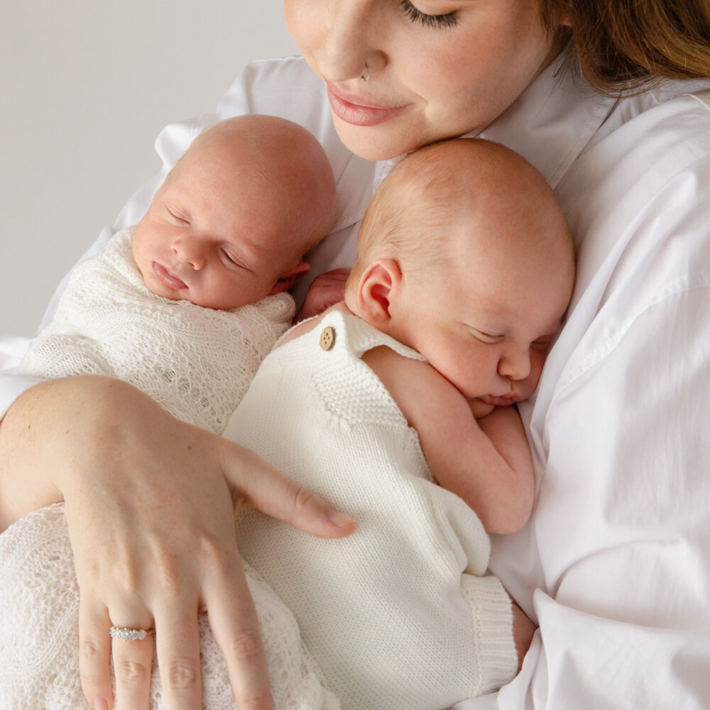 mum cradling newborn twins in white, twin newborn photography Perth