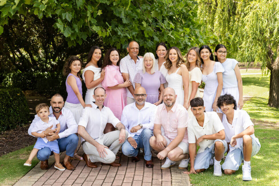 large extended family group portrait outdoors under green trees, extended family photoshoot Perth