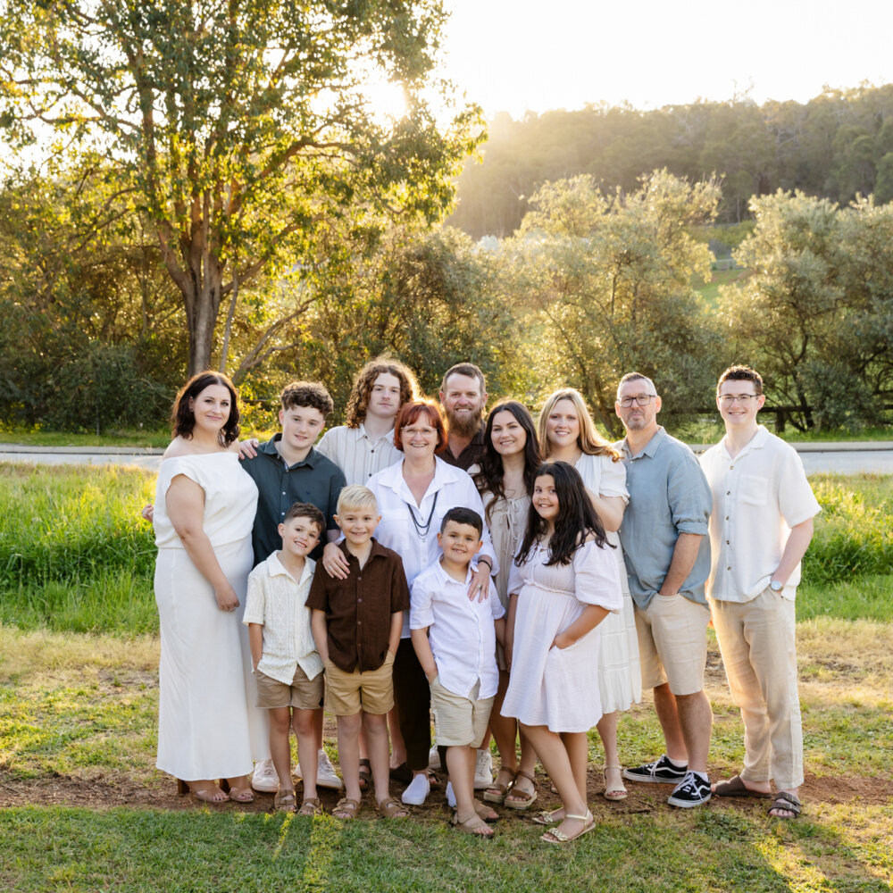 large extended family group at golden hour in green paddock, family photoshoot Perth Hills