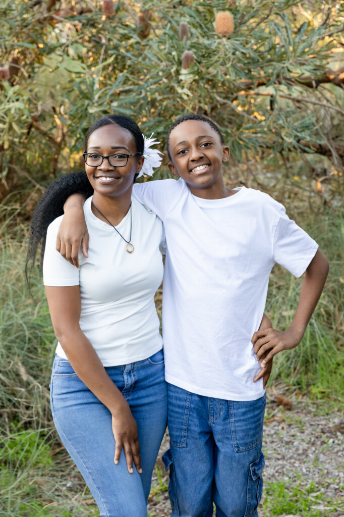 Mum and teenage son with arms around each other smiling outdoors, Perth family photos